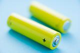 Two Yellow Batteries Against A Blue Background