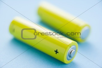 Two Yellow Batteries Against A Blue Background