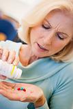 Senior Woman Pouring Pills Out Of Bottle