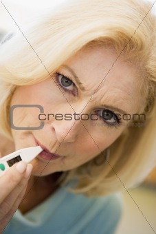 Woman Taking Her Temperature With Thermometer