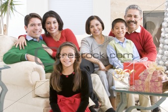 Family Sitting Around A Coffee Table And Christmas Gifts