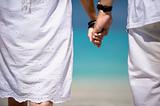 romantic couple holding hands on the beach