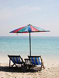 Deck chairs on a white sandy beach 