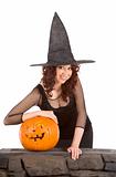 Teen girl in Halloween hat with carved pumpkin
