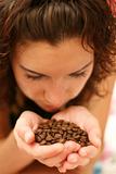 The girl smells aroma of coffee grains