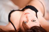 Young beautiful woman lies on bed