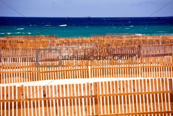 Wooden fence on deserted beach dunes 