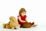The concentrated little girl playing with plush toys.