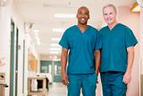 Two Orderlies Standing In A Hospital Corridor