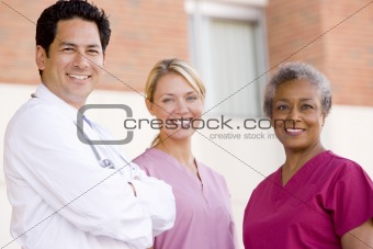 Doctor And Nurses Standing Outside A Hospital