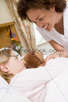 Nurse Checking Up On Young Girl In Hospital