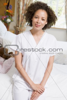 Nurse Sitting On Hospital Bed