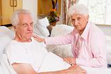 Senior Couple Sitting In Hospital,Looking Serious