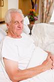 Senior Man Sitting In Hospital Bed