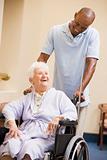 Nurse Pushing Senior Woman In Wheelchair