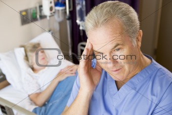 Doctor Standing In Patients Room,Looking Frustrated