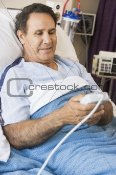 Middle Aged Man Pressing The Call Button In Hospital