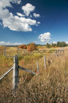 Beautiful Fall Landscape with Rustic Fence and Clouds