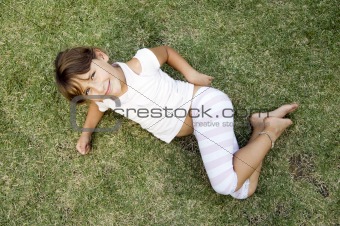 young cute girl lying on the grass