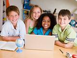 Group Of Young Children Doing Their Homework On A Laptop