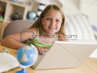 Young Girl Doing Homework On A Laptop
