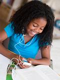 Young Girl Distracted From Her Homework, Playing With An MP3 Pla