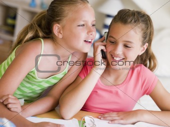 Young Girls Distracted From Their Homework, Talking On A Cellpho