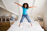Young Girl Jumping On Her Bed