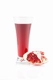 Glass of pomegranate juice and the broken pomegranate. Isolated 