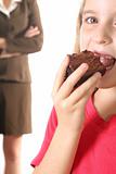 shot of a child eating brownie upclose - mom not happy