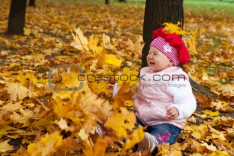 Laughing toddler and falling leaves