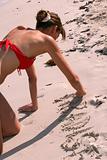 woman writes word in the sand