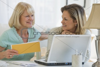 Senior woman with daughter working on laptop