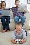 Boy playing video game while parents watch