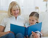 Grandmother reading a book to her grand daughter