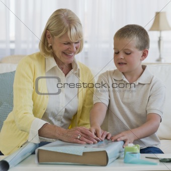 Grandmother and boy wrapping a present