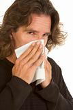Flu allergy affected middle aged man with tissue