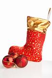 Christmas boot and red balls beside