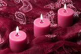 Three candles on purple cloth