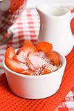 Fresh sliced strawberries with cream in a white pot
