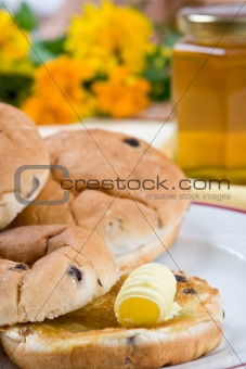 Tea cakes with melting butter (flowers and honey in the backgrou