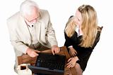 Two business associates sitting at a table with a laptop