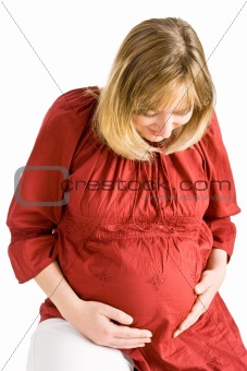 A pregnant lady looking down at her stomach