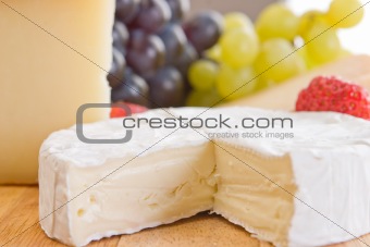 A close up of a piece of brie with grapes