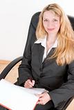 A blond business woman sitting in a black chair