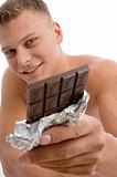 smiling muscular guy showing chocolate