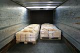 manufactured cheese on pallets in back of truck
