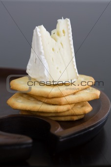 Wedge of Brie cheese on butter crackers