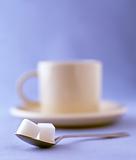 two sugar cubes with a cup of coffee on a saucer