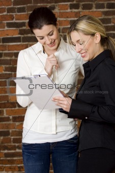 Businesswoman smiling at clipboard